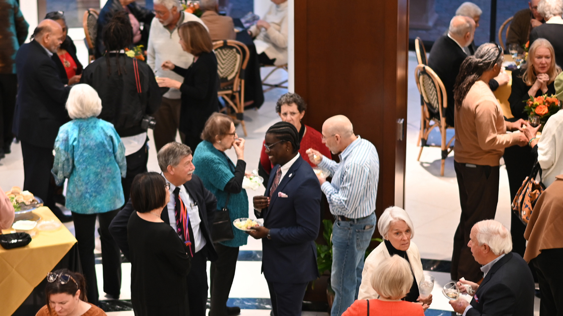 People gathered in the lobby of the Torggler, talking and eating