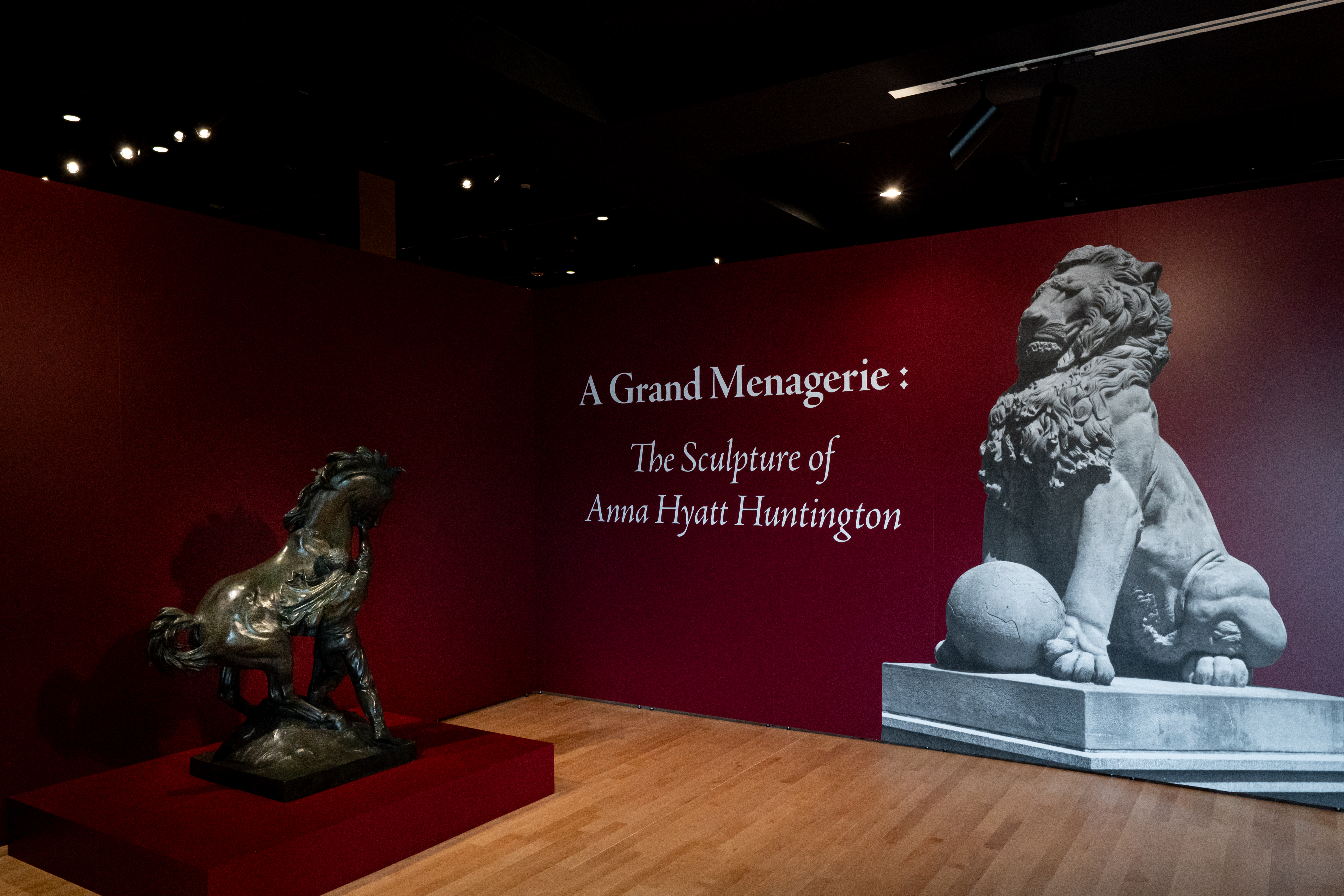 A wall reading A Grand Menagerie: The Sculpture of Anna Hyatt Huntington with a sculpture of a horse next to it