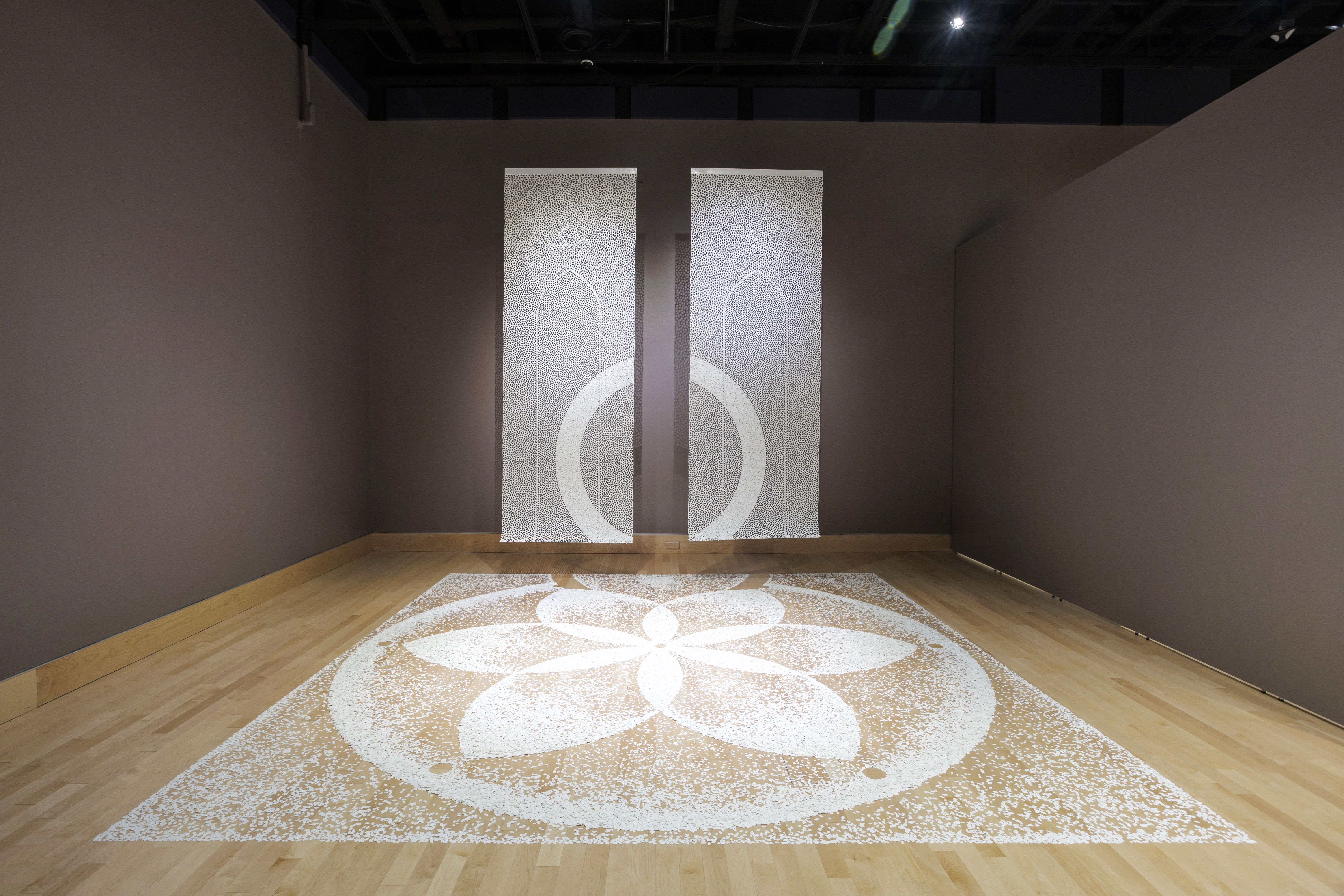 Small bits of paper make a flower design on the floor