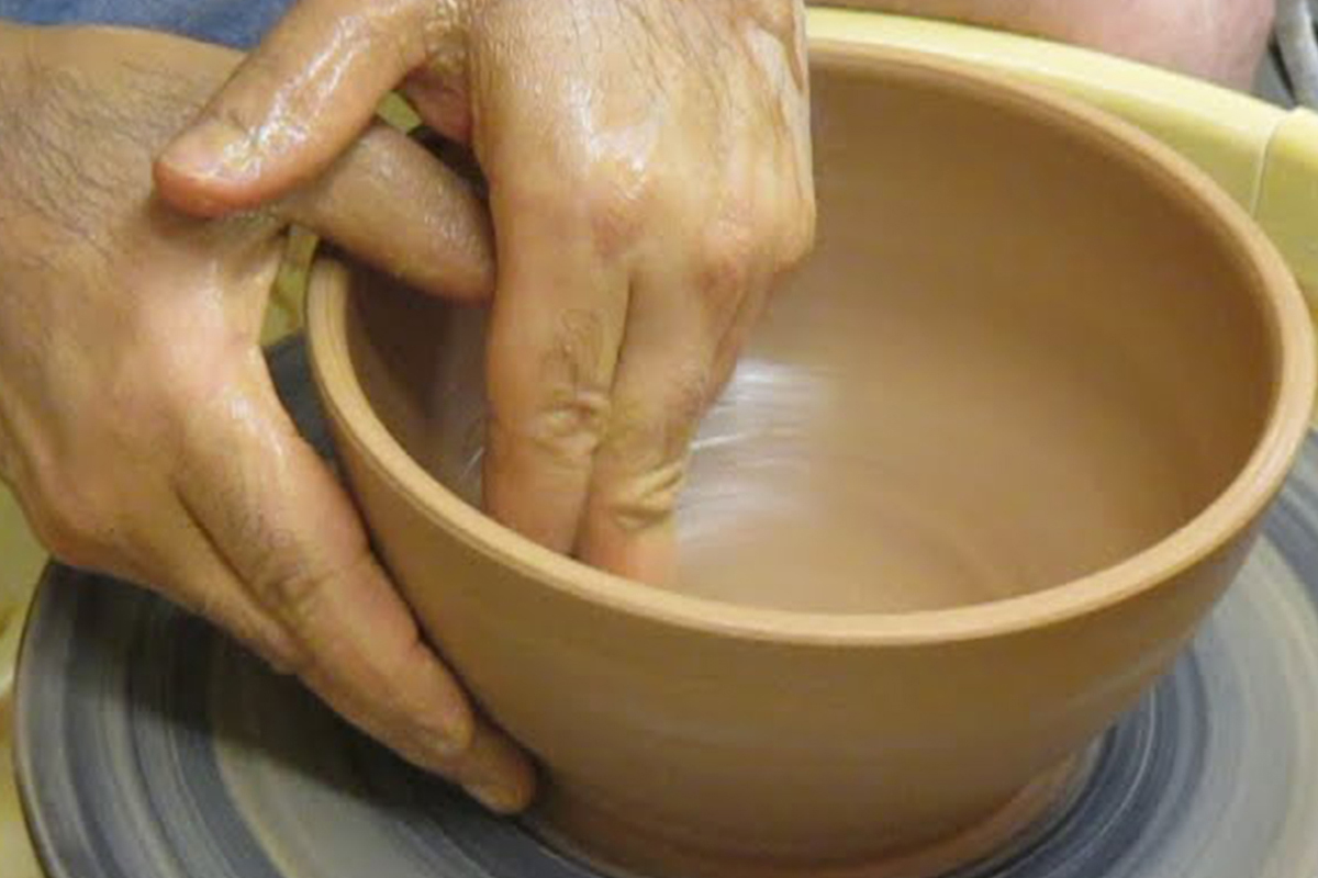 Using hands to smooth clay