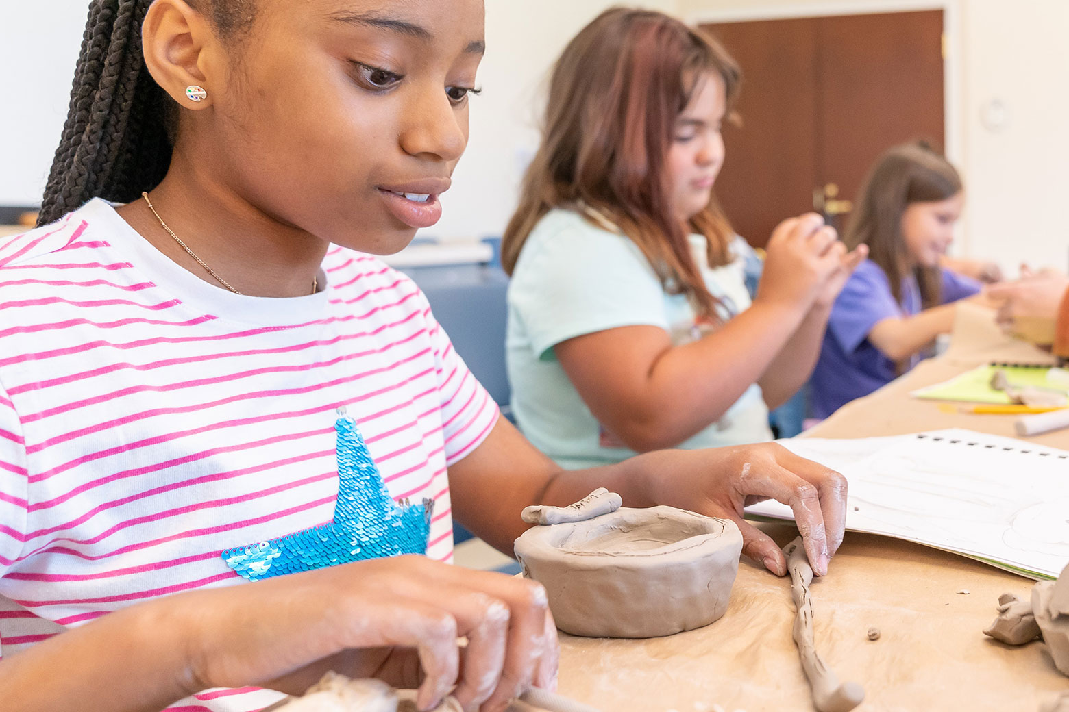 Kids hand building clay pots