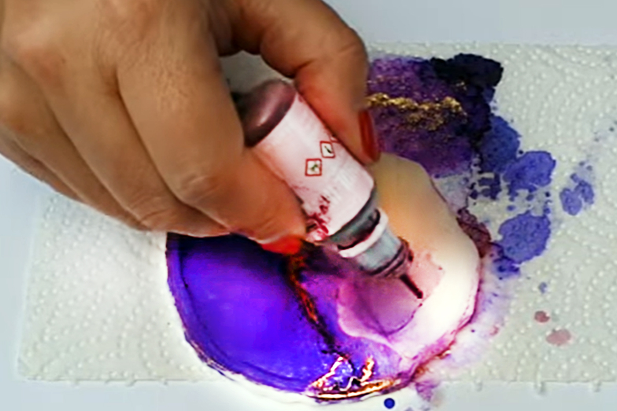 A dropper adds color to a paper towel