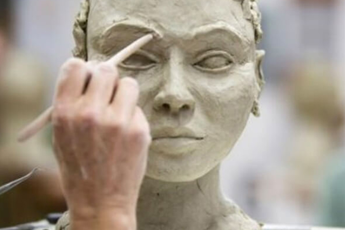 Someone sculpts a bust